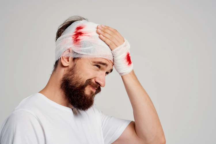 a man with a bandage on his head suffering Traumatic Brain Injuries