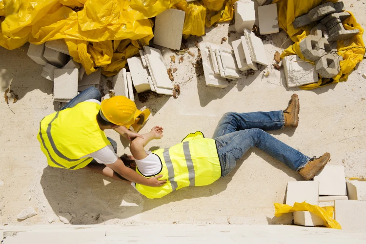 Traumatic-Brain-Injury-In-The-Construction-Industry a man in yellow vests and a man in yellow vests lying on the ground suffering traumatic brain injury